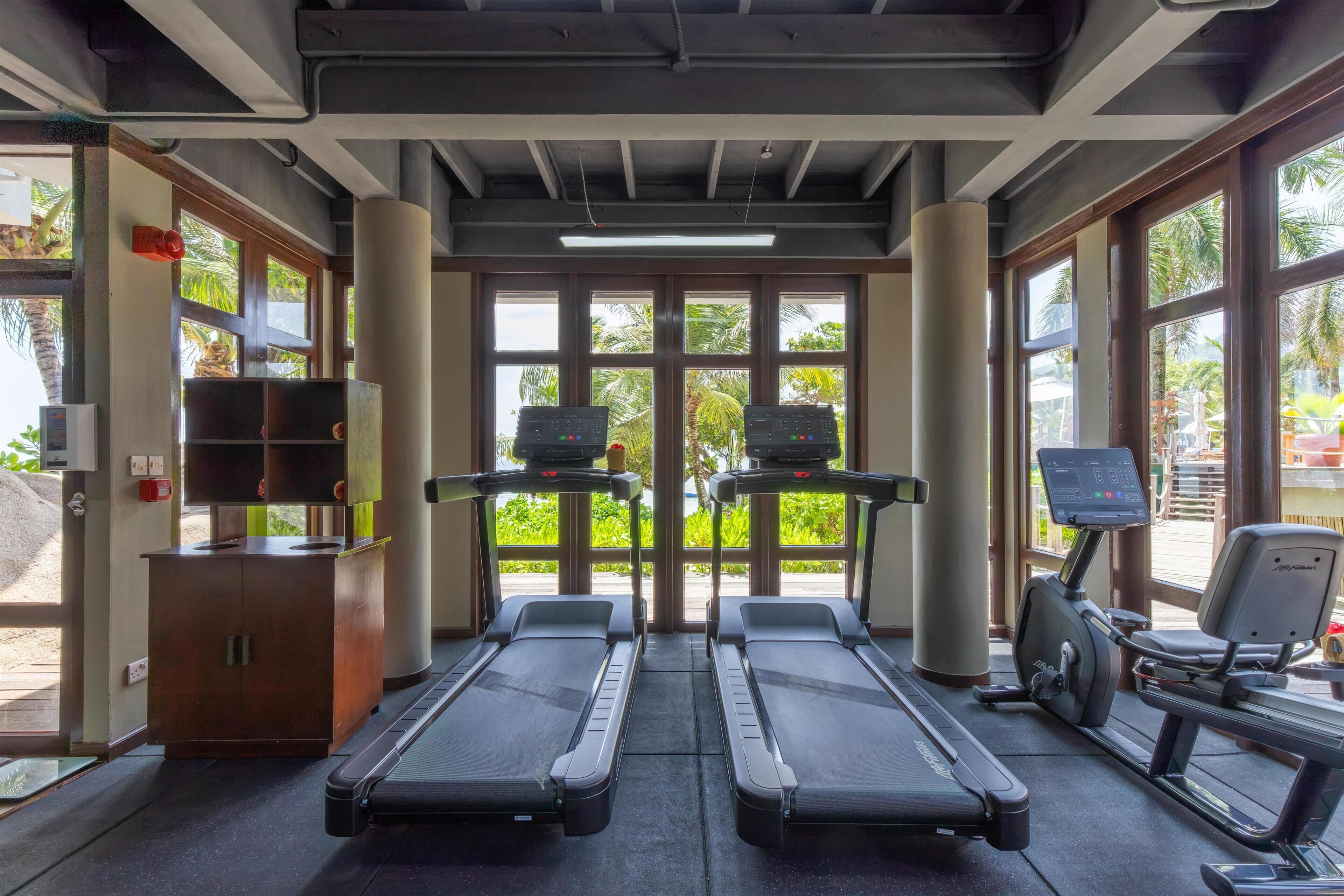A gym with treadmills, an elliptical, and a weight bench.