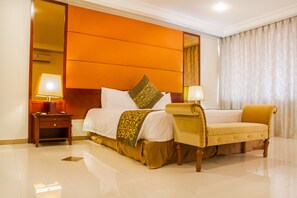 Relax in a stylish room with a large bed, bedside table, and comfortable chair.