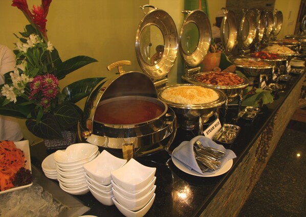 A buffet with various food items and a hot beverage station.