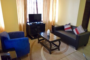 Deluxe Apartment, 1 Bedroom, Kitchen | Living room | 32-inch flat-screen TV with cable channels, TV - New Avon Apartments (Dar es Salaam)