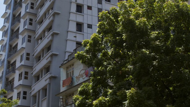 A modern hotel building with multiple floors, balconies, and a prominent sign for the New Avon Hotel. - New Avon Apartments (Dar es Salaam)