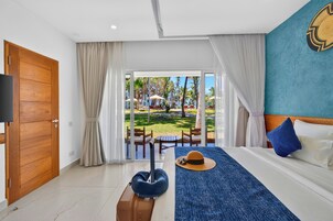 Una habitación de hotel con una cama, una maleta, un sombrero y vistas al área exterior.