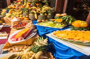 Un buffet de fruits comprenant une variété de fruits tropicaux et une nappe bleue.