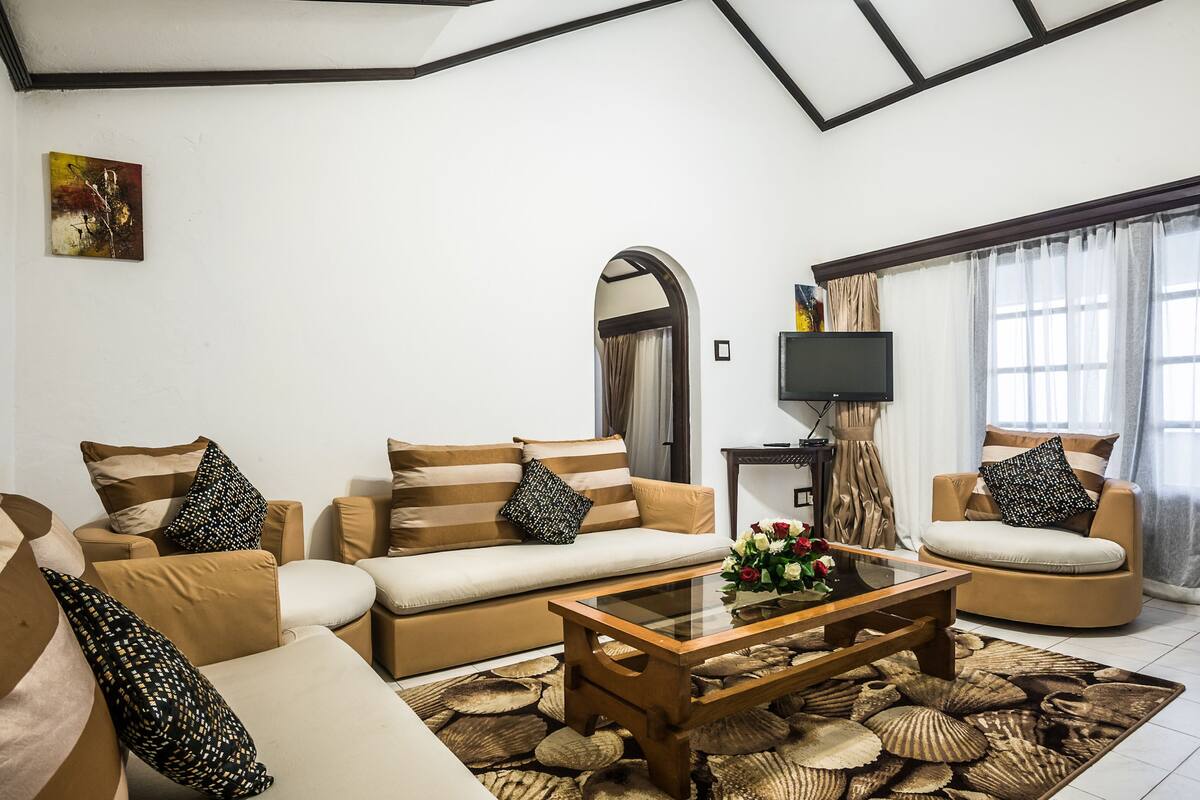 A living room with a sofa set, a coffee table, and a television.