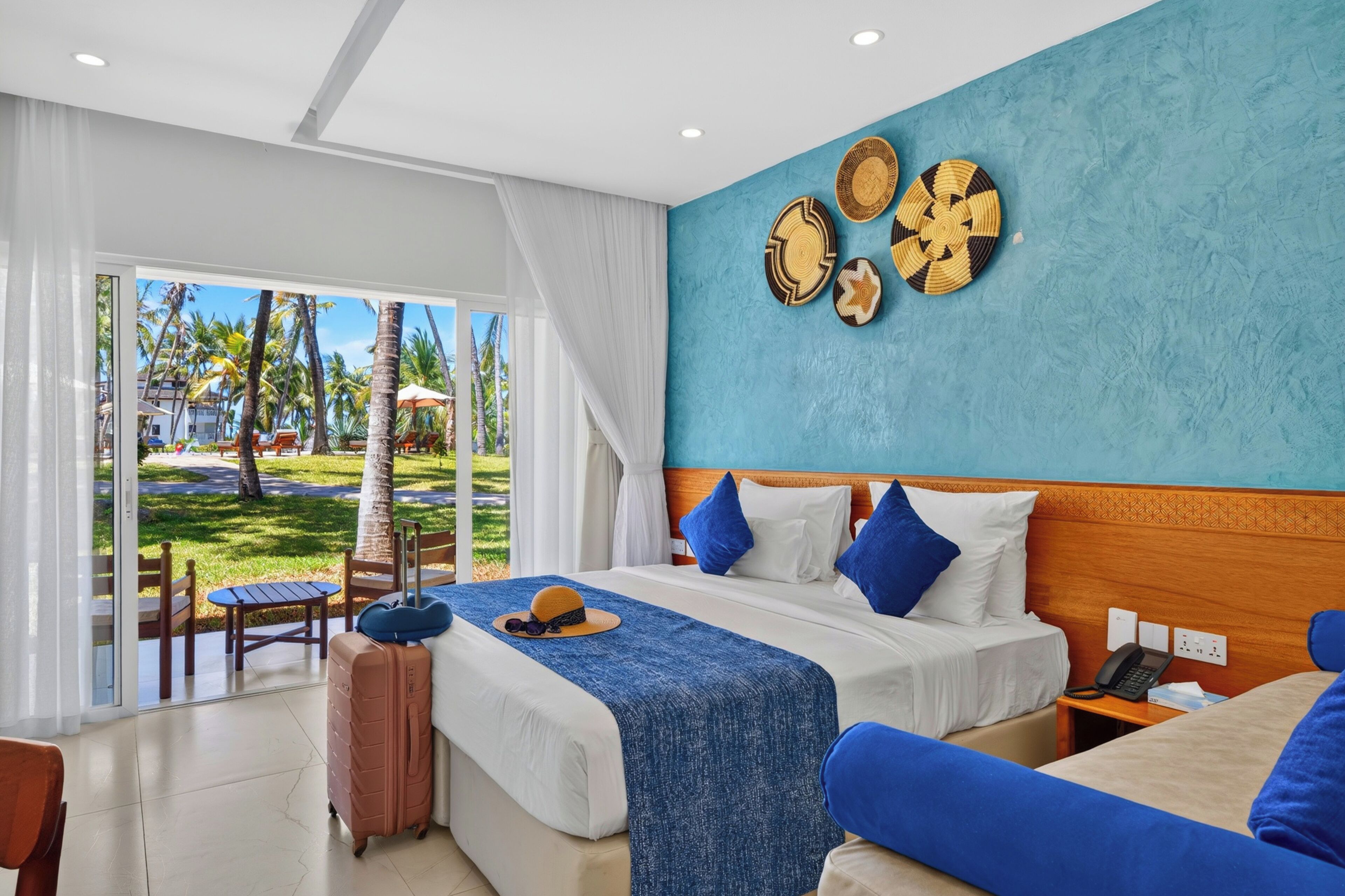 A hotel room with a bed, a desk, and a view of a pool area.