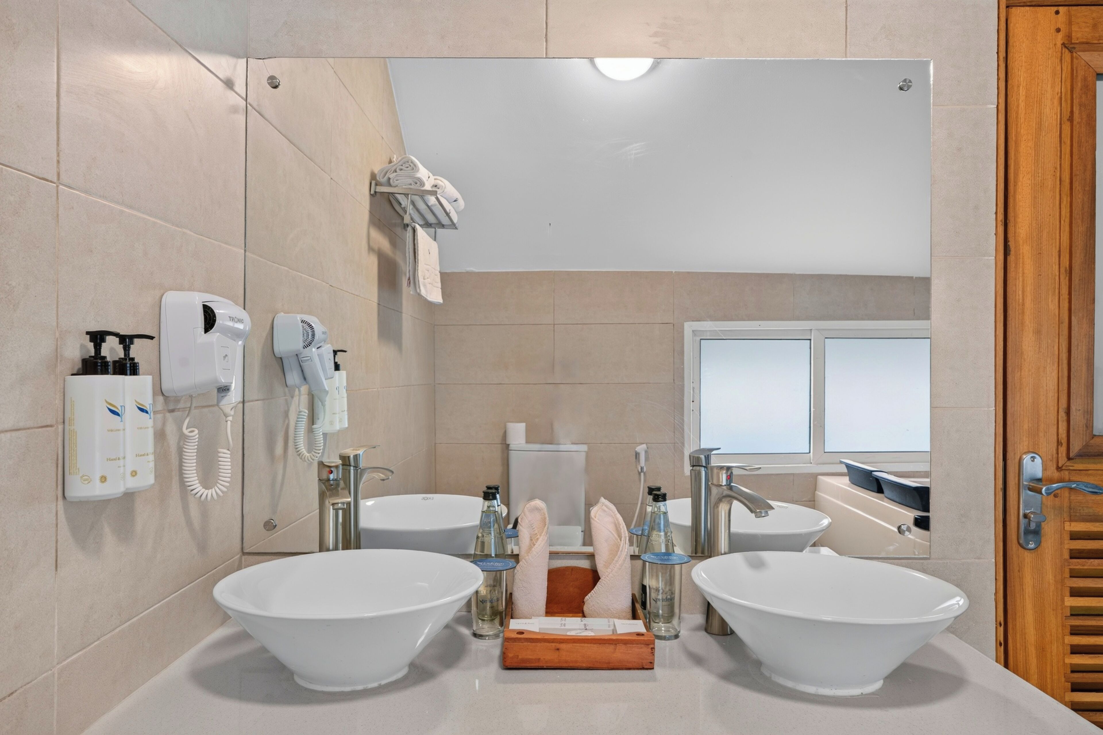 Ein modernes Badezimmer mit zwei großen Waschbecken, einer Toilette und einer Dusche.
