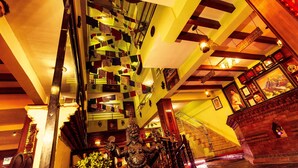 A staircase with a unique geometric pattern, a statue, and a cash register in a warmly lit interior space. - Kathmandu Eco Hotel (Kathmandu)
