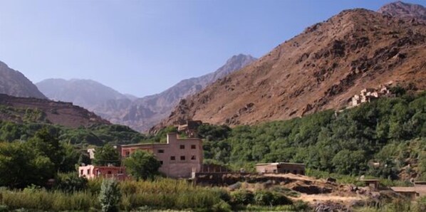 A rural village with traditional buildings surrounded by mountains.