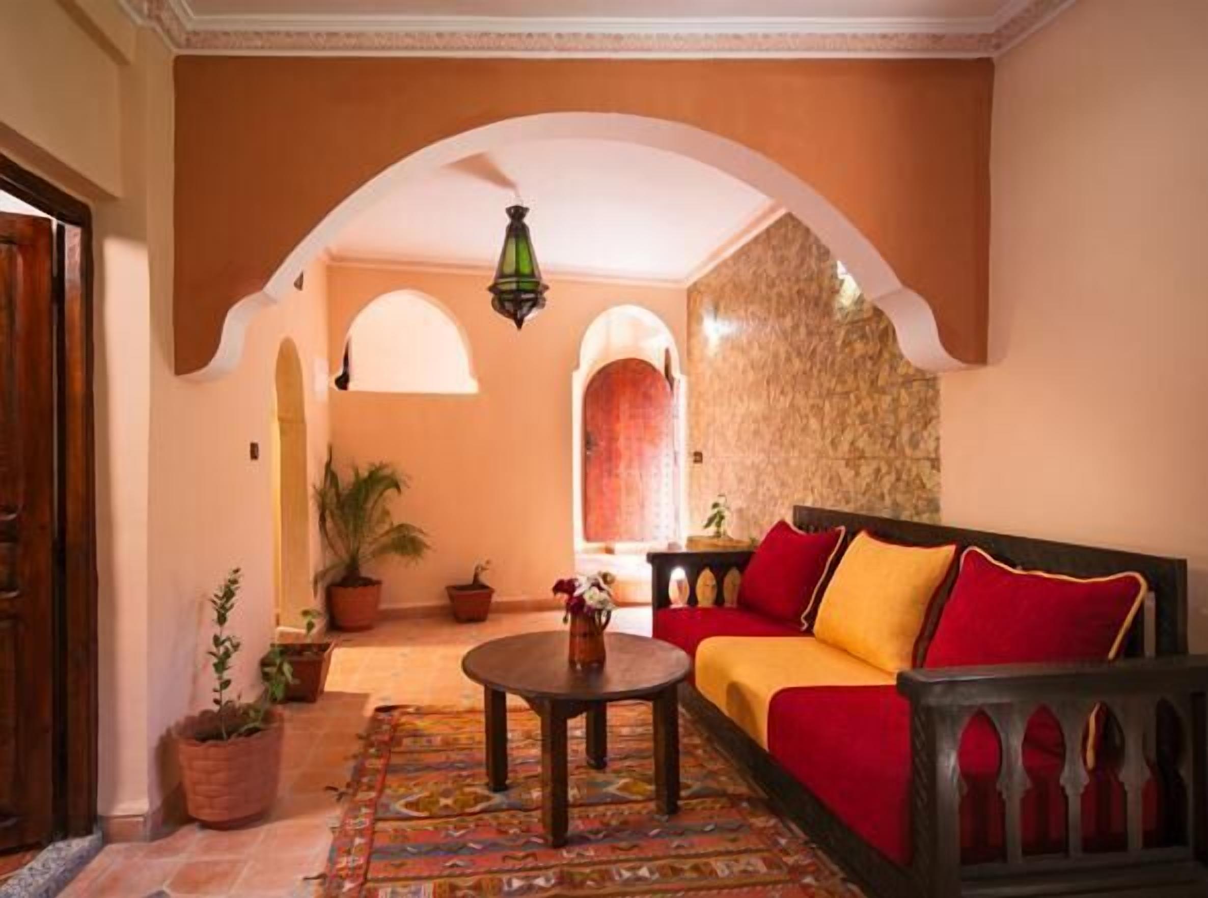 A cozy lounge area with a sofa, a coffee table, and potted plants.