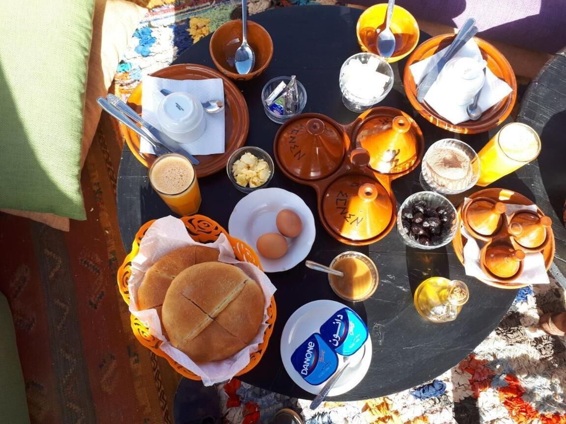 Uma mesa de café da manhã com diversos alimentos e bebidas, incluindo pão, ovos e café.