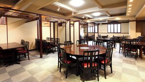 A spacious dining area with multiple tables and chairs, high ceilings with recessed lighting, and large windows allowing natural light. - Hotel Saint Paul Nagasaki (Nagasaki)