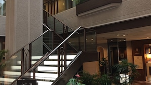 A multi-level interior with a staircase, potted plants, and a sign indicating meeting rooms. - CYPRESS HOTEL Nagoya-eki Mae (Nagoya)