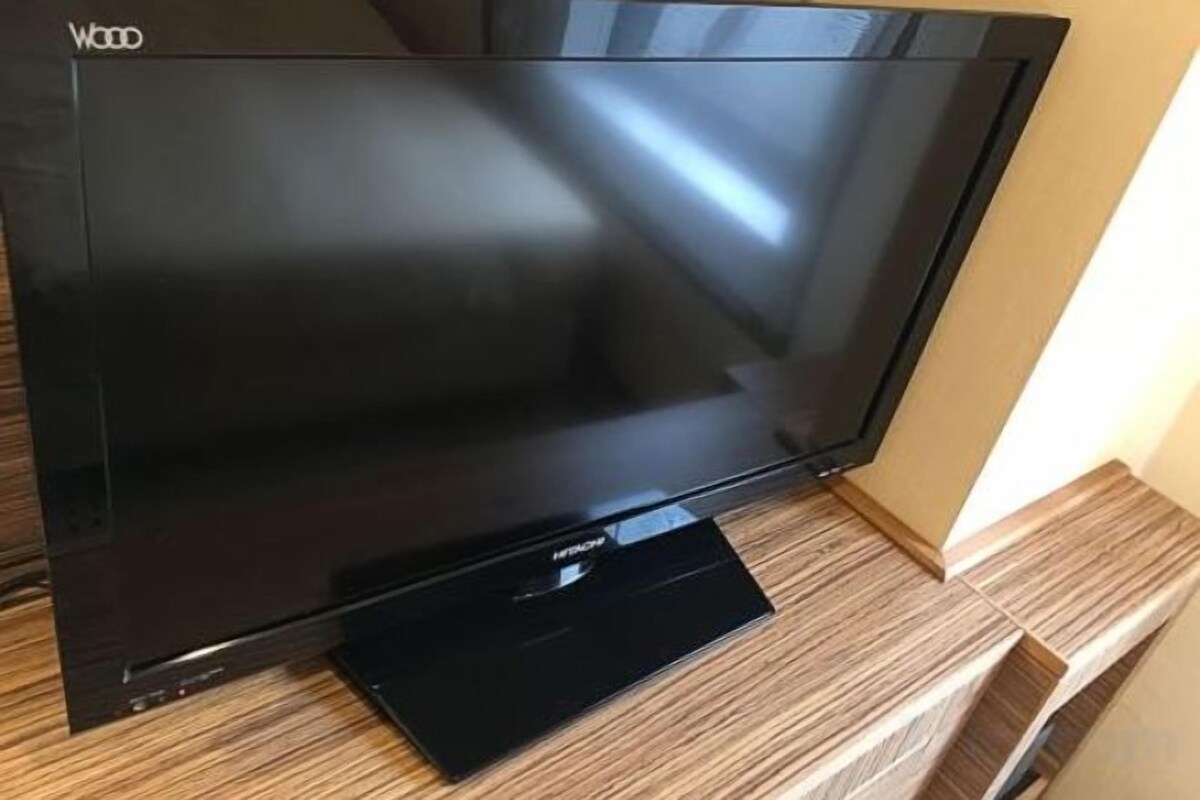 Un televisor de pantalla plana sobre un mueble de televisión de madera.