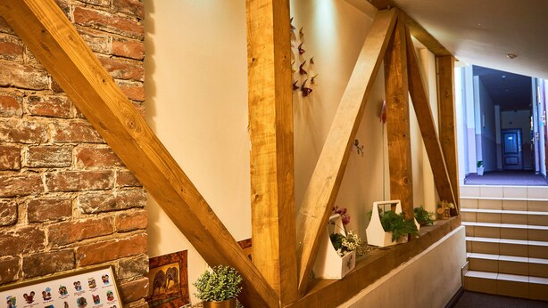 A staircase with wooden beams and a brick wall. - Leotel Hotel (Lviv)
