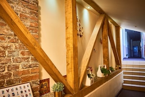 A staircase with wooden beams and a brick wall. - Leotel Hotel (Lviv)