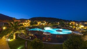 A resort with a large circular pool, lounge chairs, and umbrellas. - S'Incantu Resort (Villasimius)