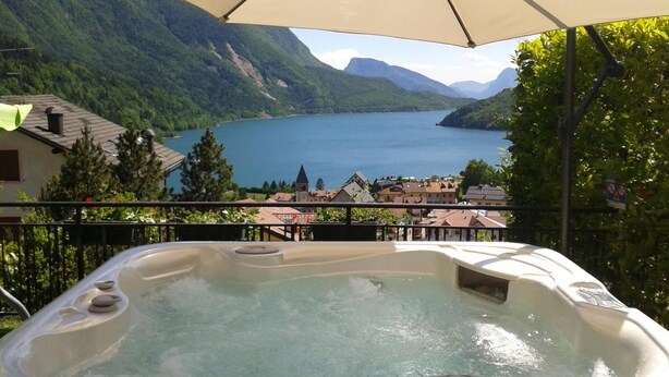 A hot tub with a view of a lake and mountains. - Hotel Florida (Molveno)