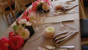 A dining area with tables set for a meal, featuring floral centerpieces and neatly arranged tableware. - Hotel Florida (Molveno)