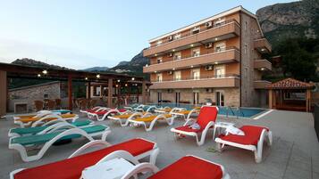 Piscine extérieure, parasols de plage, chaises longues