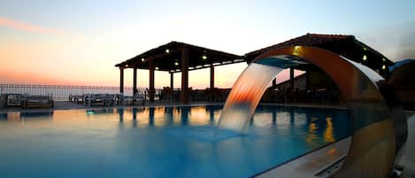 Piscine extérieure, parasols de plage, chaises longues