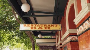 Um bar restaurante com uma placa pendurada no teto.