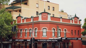 Um edifício de tijolos vermelhos com a sinalização do Glasgow Arms Hotel e Beer Garden.