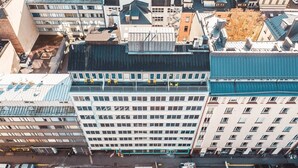 An aerial view of a cityscape with a prominent multi-story building featuring a grid of windows and a flat roof. - Forenom Aparthotel Helsinki Kamppi (Helsinki)