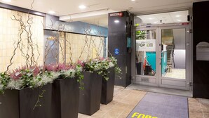 A hotel entrance with a welcome mat, black planters with greenery, and a sign for the APARK HOTEL FORENOM. - Forenom Aparthotel Helsinki Kamppi (Helsinki)