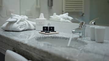 Une salle de bain avec un comptoir en granit, une serviette, un miroir et des articles de toilette.