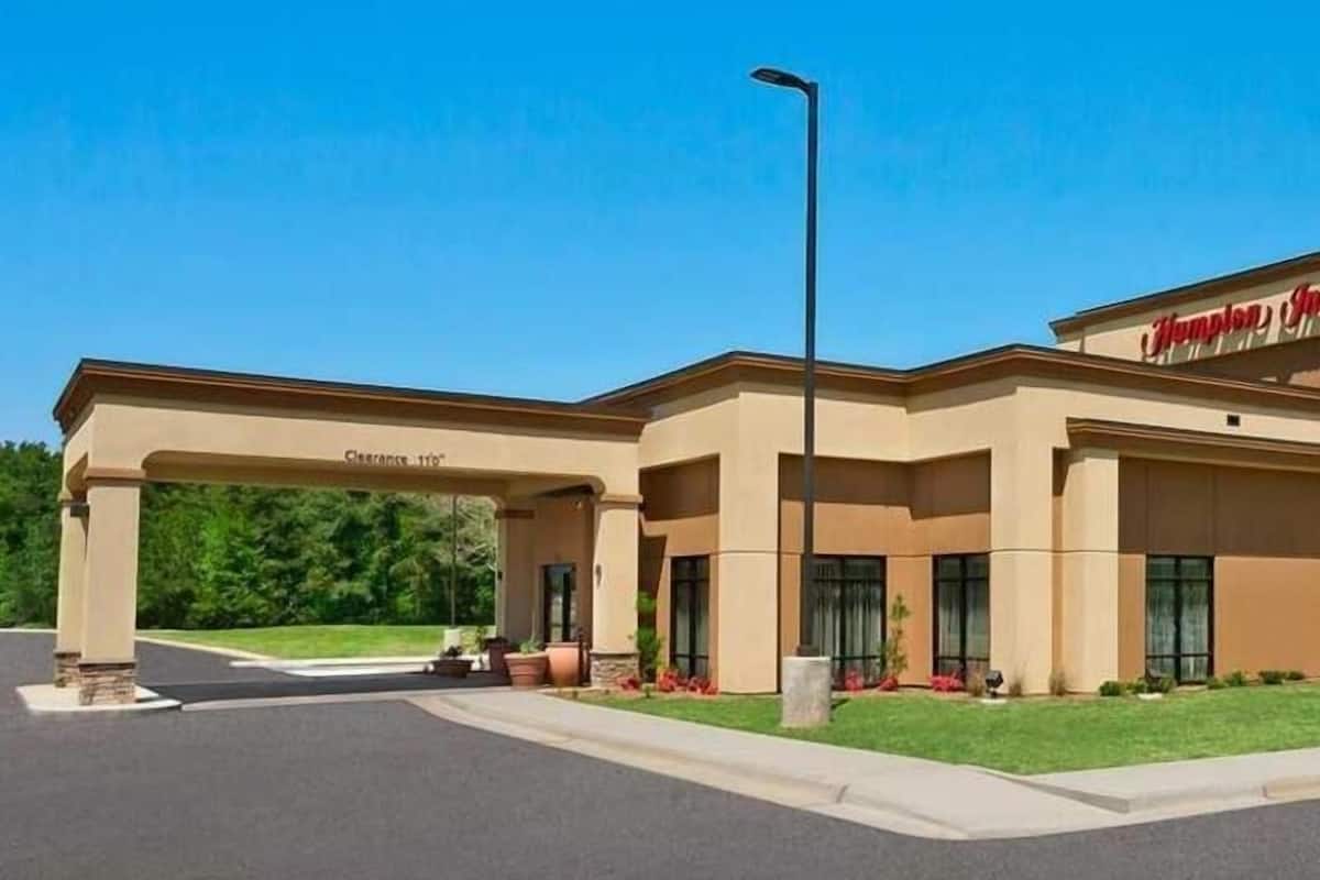 A Hampton Inn with a clear entrance, a covered parking area, and a well-maintained lawn.