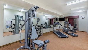 A gym with cardio machines, weight equipment, and a mirrored wall. - Baymont by Wyndham Victoria (Victoria)