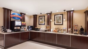A breakfast counter with a coffee machine, a microwave, and a fruit display. - Baymont by Wyndham Victoria (Victoria)