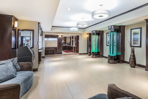 Un vestíbulo de hotel con mostrador de recepción, zona de estar y mostrador de atención al cliente.