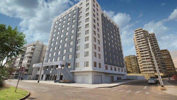 Un moderno edificio de gran altura con varias plantas y fachada plana.