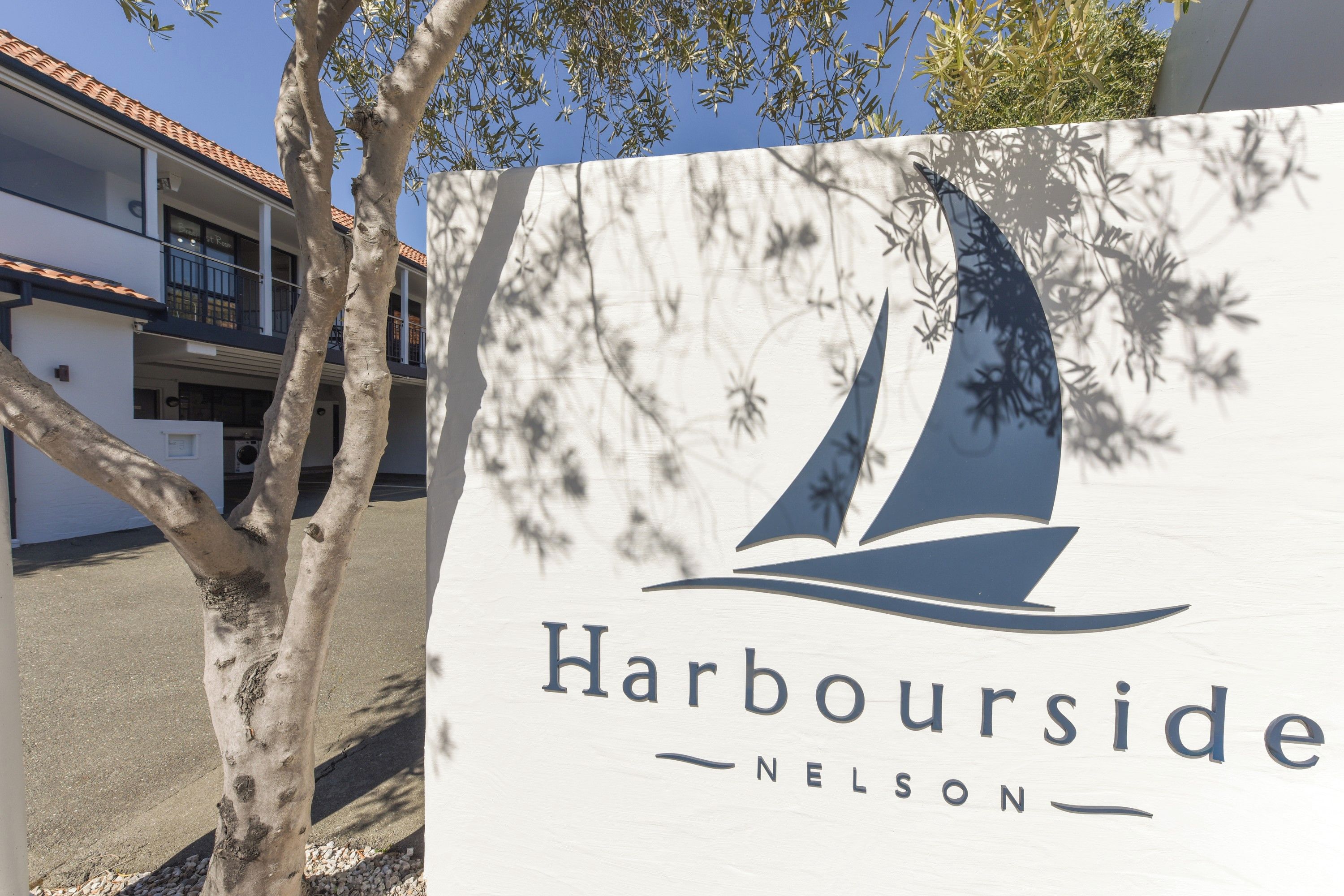 Schild für Harbourside Nelson mit einer Grafik eines Segelboots.
