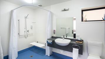 A modern bathroom with a shower, sink, and toilet.