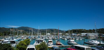 Un puerto deportivo con numerosas embarcaciones amarradas, rodeado de colinas y cielos despejados.