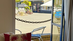Une pièce donnant sur une rue, avec une barrière et une chaise dotée d’un coussin.