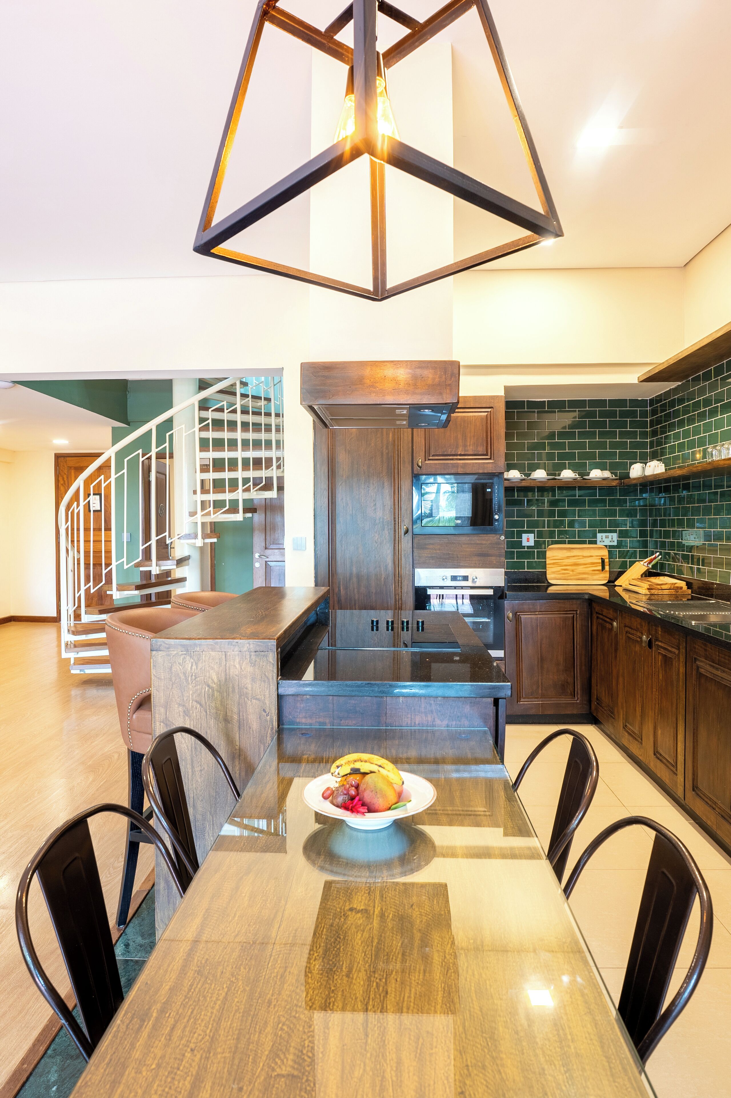 Una cocina moderna con una mesa de madera, sillas y un frutero.