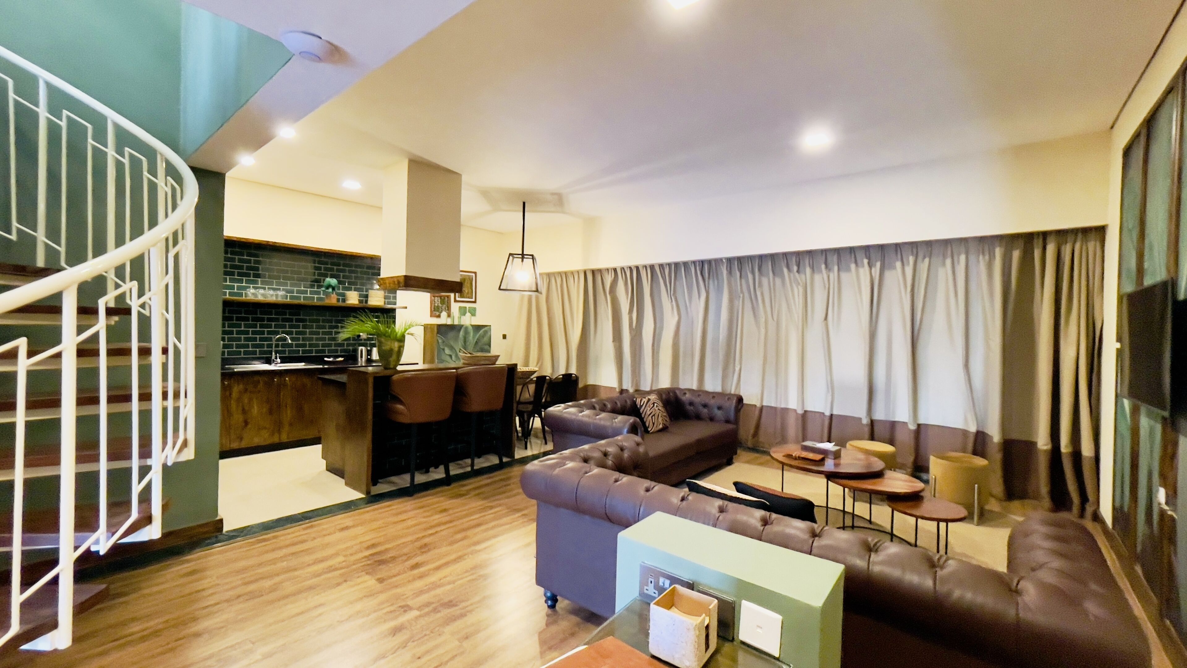 A modern living room with a sofa, coffee table, and a dining area with chairs.