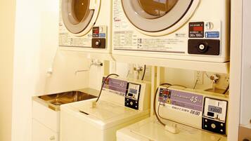 A laundry area with two front-loading washing machines and a sink.