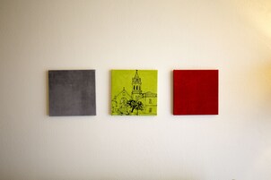 Tres obras de arte cuadradas en una pared.