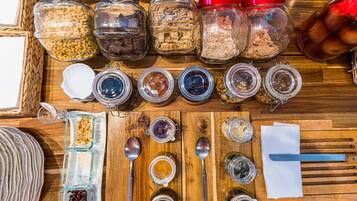 A wooden table with various jars containing different food items and utensils.