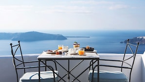 A table with breakfast items and a view of the sea. - Remezzo Villas (Santorini)