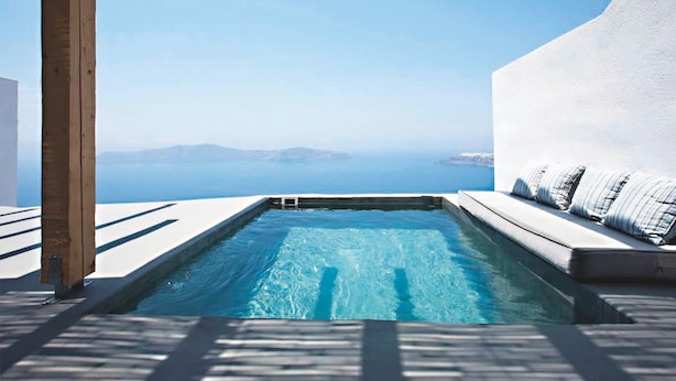 A infinity pool with a clear view of the sea and distant land. - Remezzo Villas (Santorini)