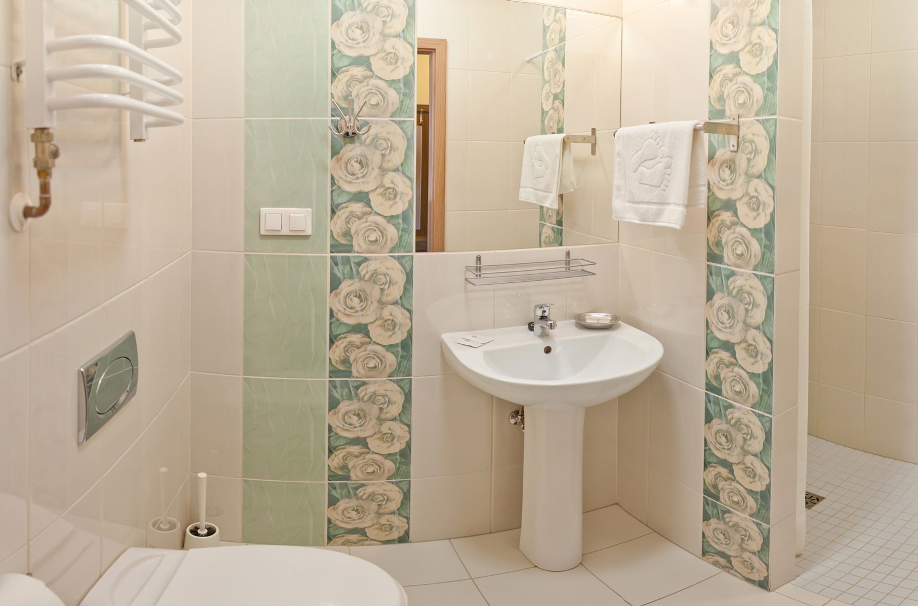 A bathroom with a sink, toilet, and towel rack.
