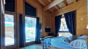 Una habitación de cabaña de madera con una cama, un escritorio y un televisor.