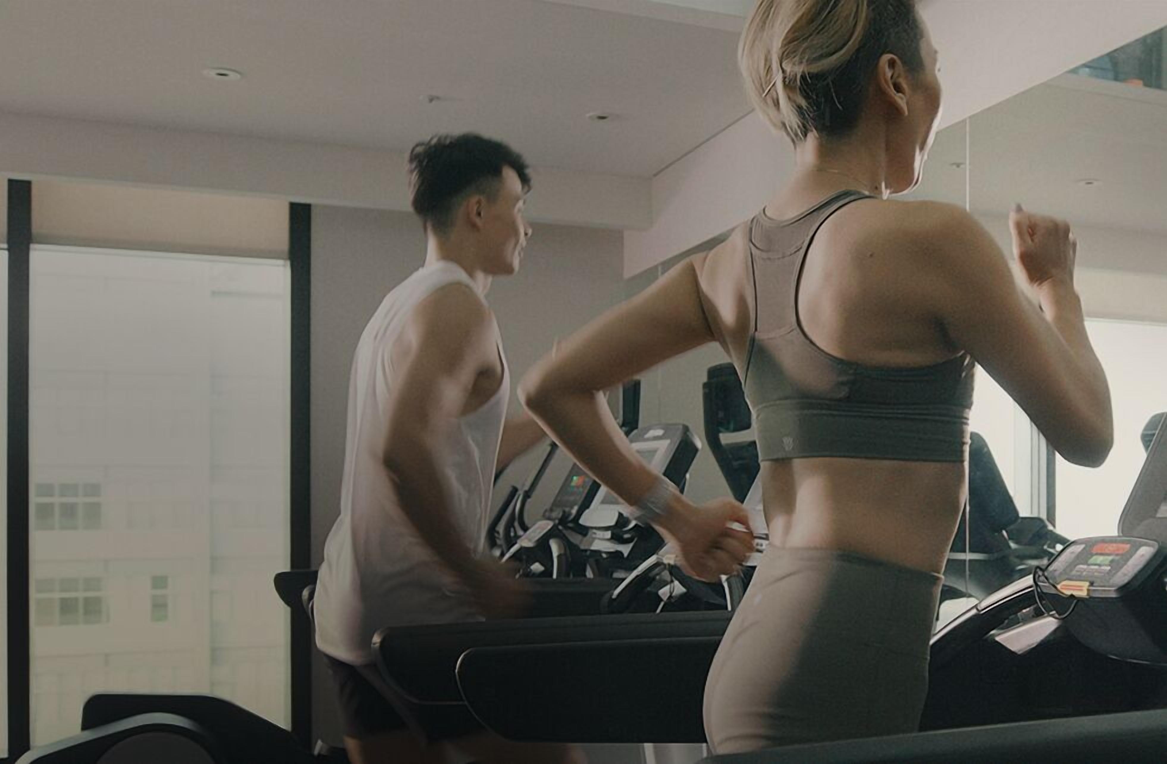 A gym with treadmills and a large mirror.