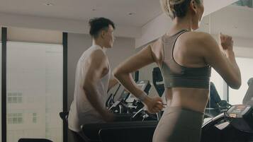 A gym with treadmills and a large mirror.