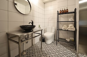A bathroom with a black sink, white toilet, and a shelf with toiletries. - Seoul Loft Apartments - SLA 7 Night Minimum (Seoul)